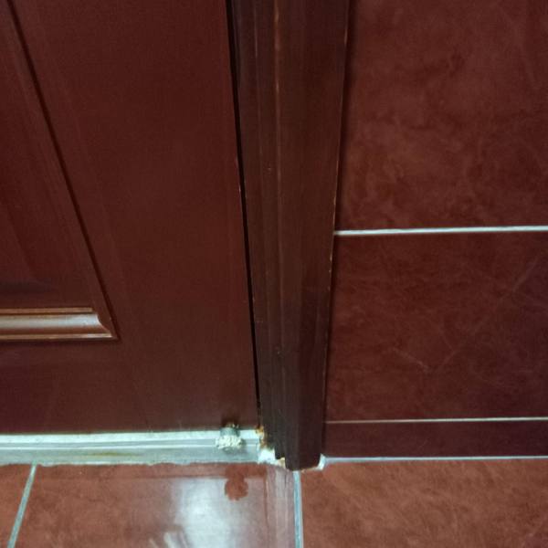 Repaired door frame bottom at tiled floor